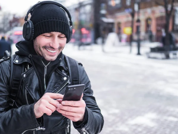 Beyaz delikanlı kış town bölgesindeki walkin kulaklıklar müzik dinlemek — Stok fotoğraf