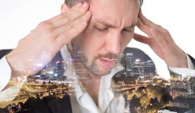 Çift Kişilik fuar. Megapolis. Takım elbiseli genç adam beyaz arka plan karşı dururken kafasını dokunmaktan ve gözleri koruma kapalı.