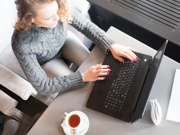 Pekerja lepas wanita bekerja di kafe dengan laptop mockup, secangkir kopi atau teh . — Stok Foto