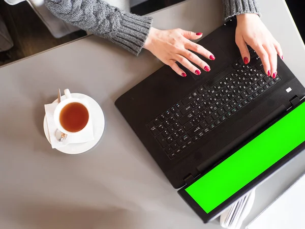 Mãos femininas digitando no teclado do laptop no café. Imagem dentada. tela verde . — Fotografia de Stock