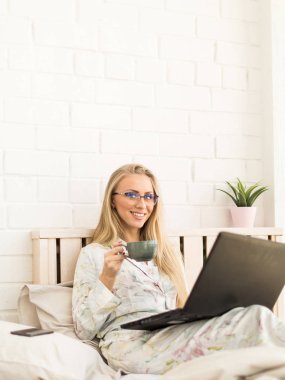 gözlük gülümseyen iş üstünde laptop ve yatakta kahve içmek