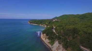Kıyı boyunca uçan uçak video. Bir yol kıyıya geçmektedir. Mavi gökyüzü. İyi bir hava