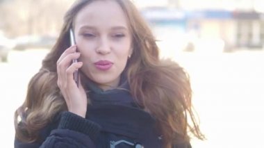 Güzel bir kadın o caddede yürür süre onu cep telefonundan konuşuyor. Smartphone konuşmak yürüme şehirde genç kadın.