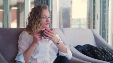 kadın bir kafede oturan ve çay içme. O biraz gergin ve etrafına bakıyor