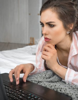 genç kadın evde çalışıyor. Yatak, laptop. Eğitim. serbest.