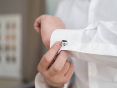 Yakın bir el adamın nasıl giyer beyaz gömlek ve kol düğmesi.