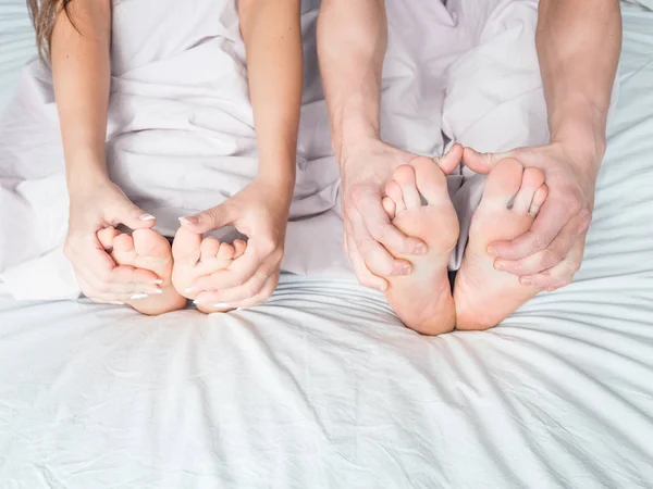 Feet and hands of a young couple that lying on the bed at honeymoon. Couple in love. Concept : love, sweetheart, sweet, activity, lifestyle. — Stock Photo, Image