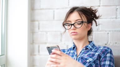 Smartphone mutlu gülümseyen içeride kullanan genç ve güzel kadın. Kız sms manifatura app akıllı telefon evde kullanma