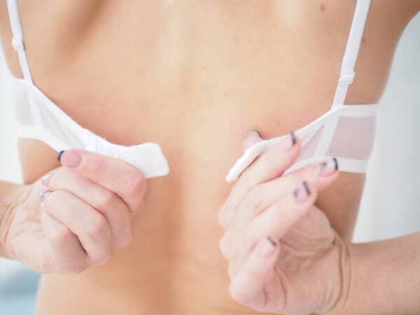 крупным планом на спине женщины с помощью руки попытаться снять лифчик, расстегнув застежку лифчика
