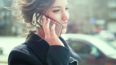 Çekici bir kadın telefonda konuşurken kaldırımdan yürür. yakın çekim.