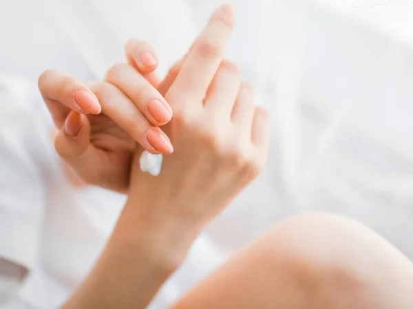 Gros plan de mains féminines appliquant crème pour les mains — Photo