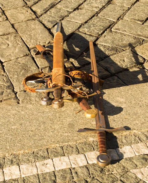 Velhas espadas enferrujadas no chão de pedra — Fotografia de Stock