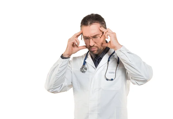 Medelålders läkare man bär rock och stetoskop stående isolerad på vit bakgrund lider av huvudvärk desperat och stressad på grund av smärta och migrän. — Stockfoto