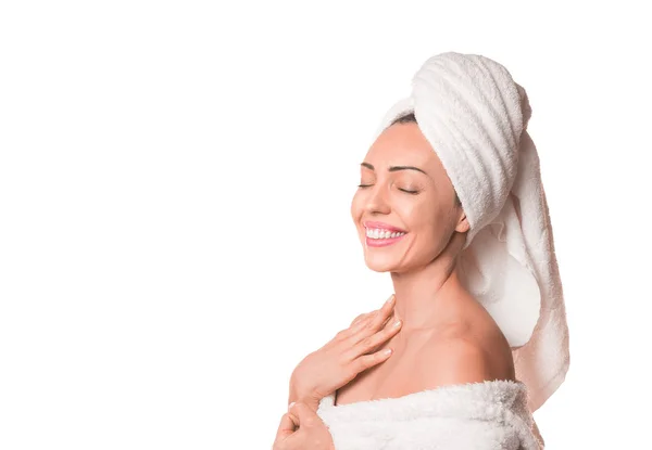 Spa περιποίησης της ομορφιάς γυναίκα ξήρανση των μαλλιών με πετσέτα στο κεφάλι μετά τη θεραπεία ντους. Όμορφη χαμογελαστή γυναίκα αγγίζει μαλακό δέρμα με κλειστά μάτια απομονώνονται σε λευκό φόντο. — Φωτογραφία Αρχείου