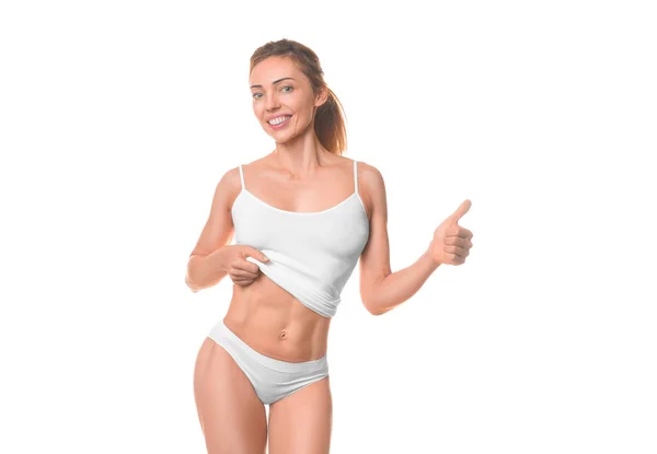 Mujer sonriente mostrando su cintura y mantiene el pulgar hacia arriba. Aislado sobre blanco . — Foto de Stock