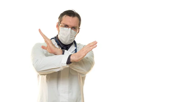 Manlig läkare visar stoppskylt. Läkare i ansiktsmask visar stoppskylt med korsade händer. Isolerad på vitt. — Stockfoto
