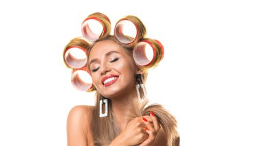 Happy young woman with hair curlers on her head isolated on white. clipart