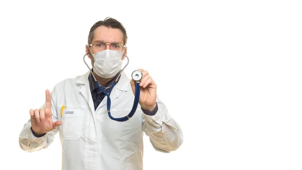 Close-up photo of male doctor in a protective mask using stethoscope and keeps finger in attention sign. Isolated on white. — Stock Photo, Image