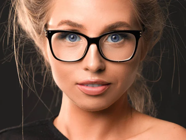 Szoros portré egy szemüveges nőről sötét háttér felett — Stock Fotó