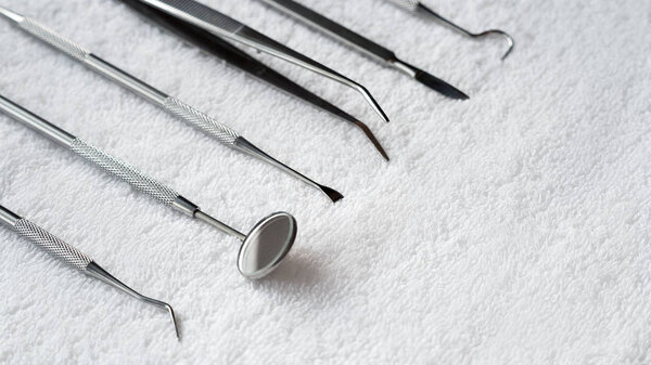 Close up photo of a set of a dental tool on a white hapkin.
