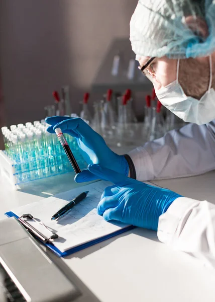 En läkares händer i ett labb. Anteckna vid forskning om antivirusvaccin. — Stockfoto