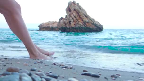 Sea waves washing over tanned female feet. — Stok video