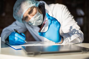 Araştırmacıların elindeki kan örneğine yakından bakın..