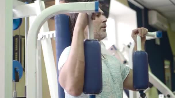 Middle aged man exercising on chest butterfly machine. — Stock Video