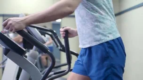 Vista de cerca de un torso masculino en un entrenamiento cardiovascular en el gimnasio . — Vídeo de stock