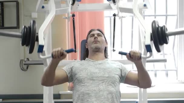 Orta yaşlı bir adam göğüs presi makinesinde egzersiz yapıyor.. — Stok video