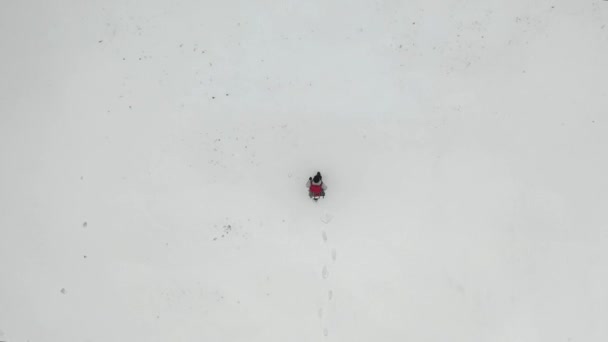 Blick von oben auf einen Menschen, der am Schneefeld vorbeigeht. — Stockvideo
