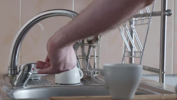 Male hands close up washing mug after morning coffee. — Stock Video