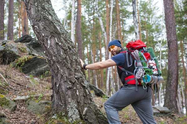 Randonneur avec un sac à dos dans la forêt regardant la caméra . — Photo