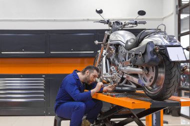 Motosiklet tamir eden adam modern bir atölyede asansörle yükseldi..