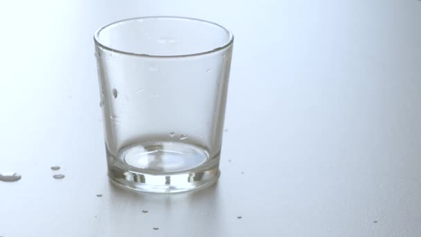 L'eau est versée dans un verre transparent et une main de personnes prend le verre . — Video