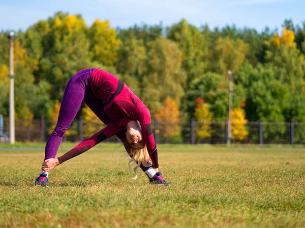 Foto de una mujer flexible se extiende al aire libre . — Foto de Stock