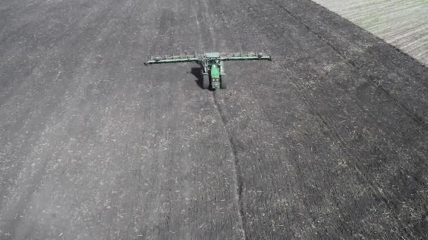 Groene trekker ploegt de grond. Uitzicht vanaf de drone. — Stockvideo