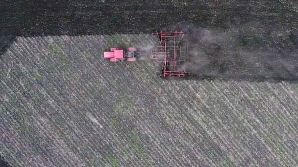 Roter Traktor pflügt den Boden um. Blick von der Drohne. — Stockvideo