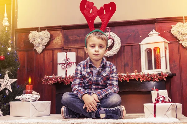 Мальчик в ожидании Санта-Клауса, сидящего на столе — стоковое фото
