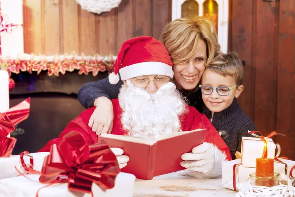 Мать и сын посмотрите на список пожеланий с Санта-Клаусом — стоковое фото