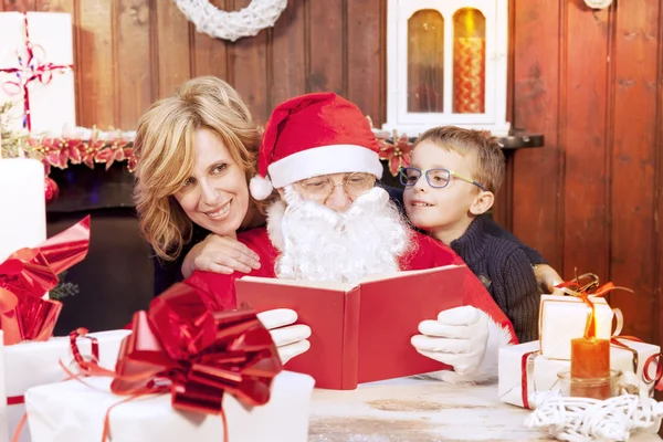 Мать и сын посмотрите на список пожеланий с Санта-Клаусом — стоковое фото