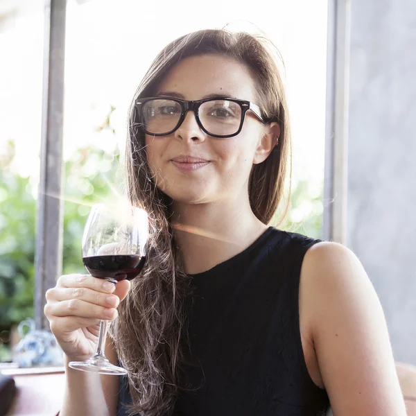 Beautiful young woman holding a glass of wine — Stock Photo, Image