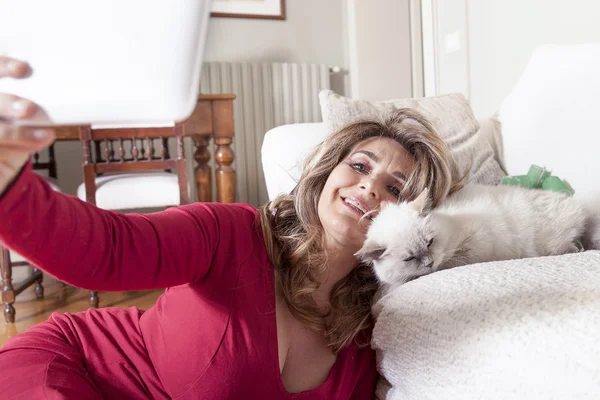 Beautiful lady with red dress takes a selfie with her kitten — Stock Photo, Image