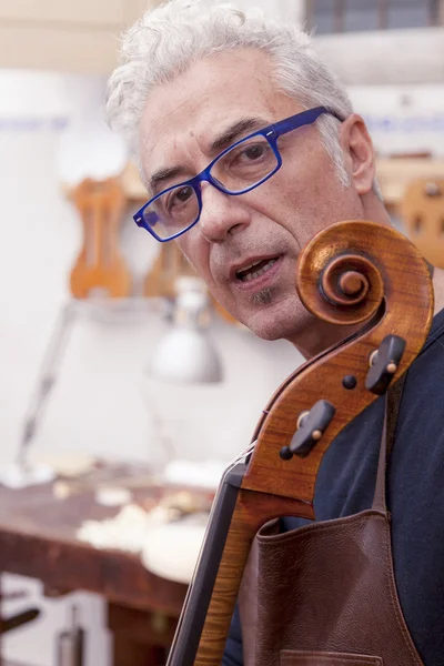 Портрет зрілого творця скрипки під час тестування скрипок у його — стокове фото