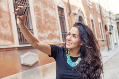 bir bisikleti ile genç ve güzel kız bir selfie şehirde alır.