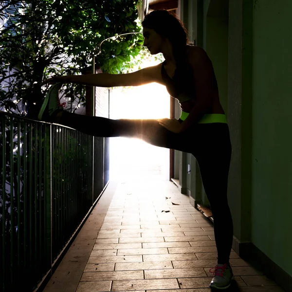 Atleta muito feminino faz alongamento após exercícios de ginástica — Fotografia de Stock