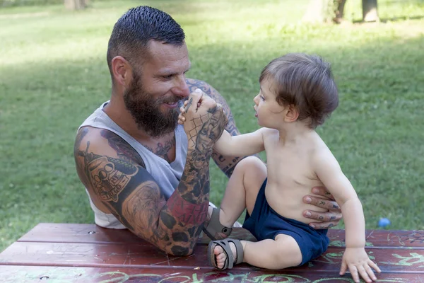 Tatoué père s'amuser avec son fils dans le parc — Photo