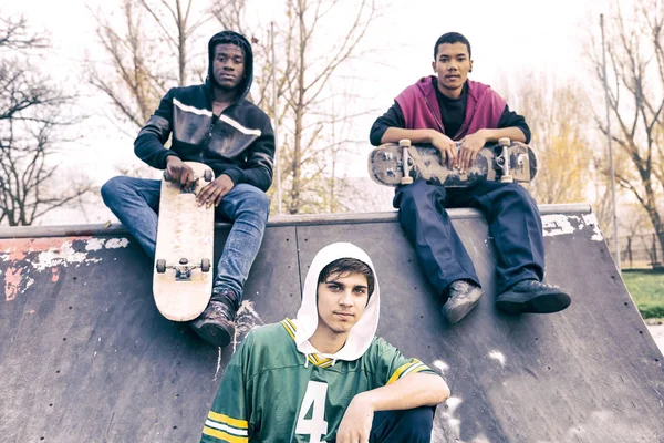 Groep van jonge volwassenen zitten op een helling met skateboard — Stockfoto