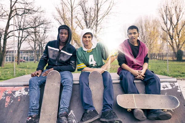 Groep van jonge volwassenen zitten op een helling met skateboard — Stockfoto