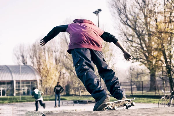 Jeune skateboarder sautant sur une rampe en plein air — Photo